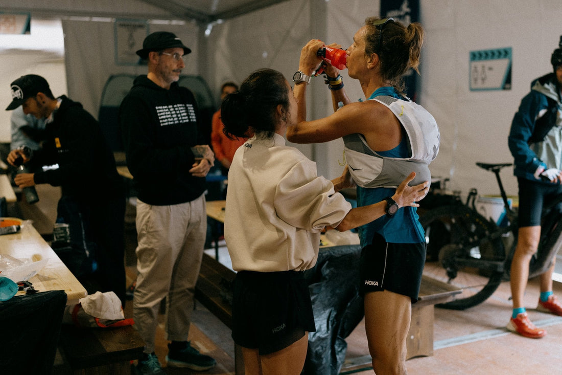 Trailová běžkyně pije na občerstvovací stanici během ultramaratonu