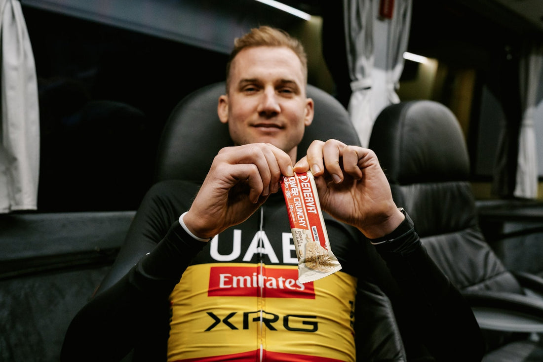 Cyklista UAE Team Emirates XRG s tyčinkou ENERVIT Power Crunchy v týmovém autobusu