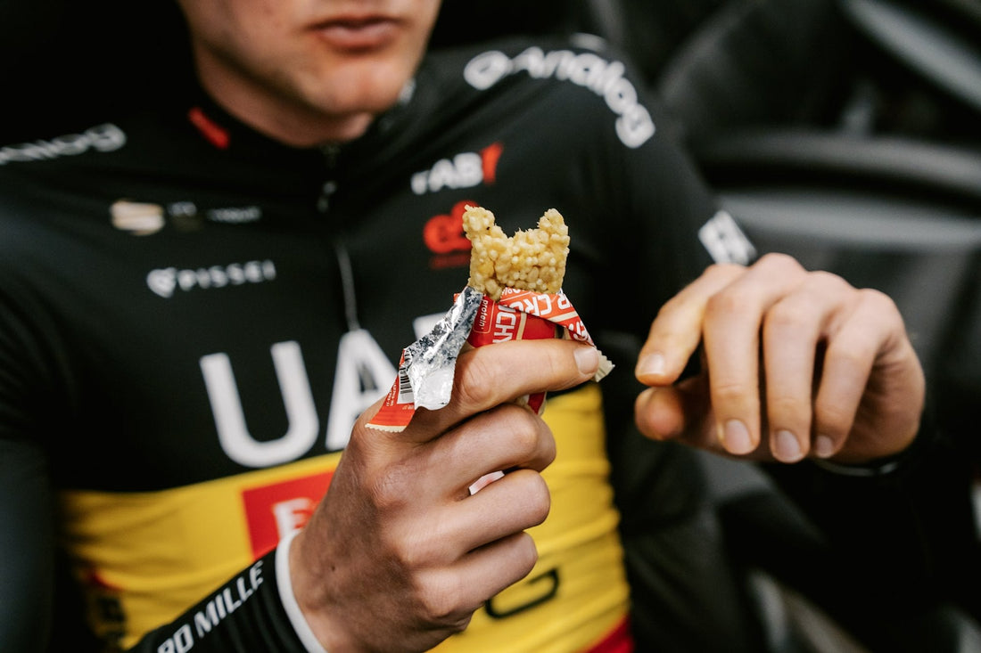 Cyklista UAE Team Emirates XRG jí tyčinku ENERVIT Power Crunchy Bar