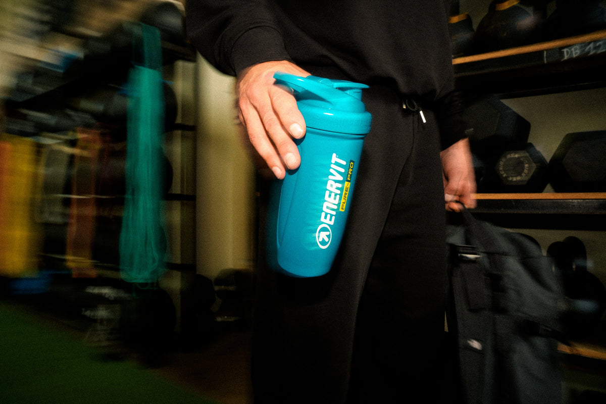 ENERVIT Shaker Reforce 700 ml v ruce sportovce